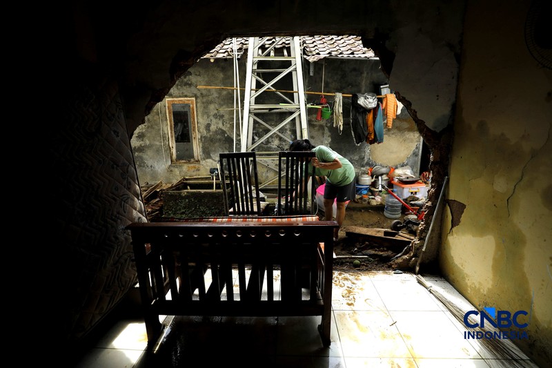 Warga membersihkan properti rumah yang terkena banjir di Kampung Carewed, Desa Cijayanti, Babakan Madang, Kabupaten Bogor, Jawa Barat, Kamis (12/2/2026). (CNBC Indonesia/Tri Susilo)
