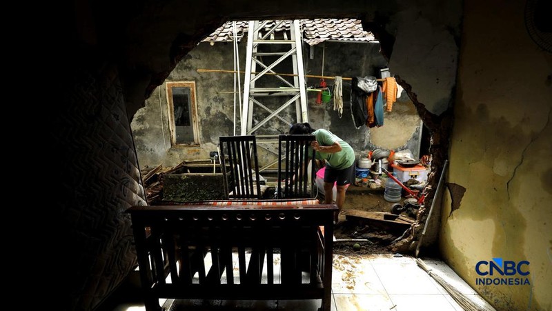 Warga membersihkan properti rumah yang terkena banjir di Kampung Carewed, Desa Cijayanti, Babakan Madang, Kabupaten Bogor, Jawa Barat, Kamis (12/2/2026). (CNBC Indonesia/Tri Susilo)