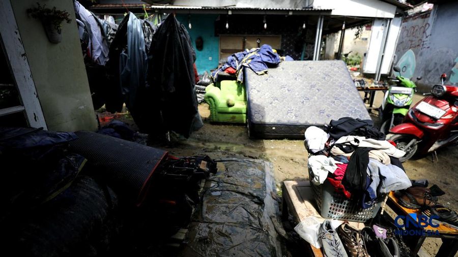 Warga membersihkan properti rumah yang terkena banjir di Kampung Carewed, Desa Cijayanti, Babakan Madang, Kabupaten Bogor, Jawa Barat, Kamis (12/2/2026). (CNBC Indonesia/Tri Susilo)