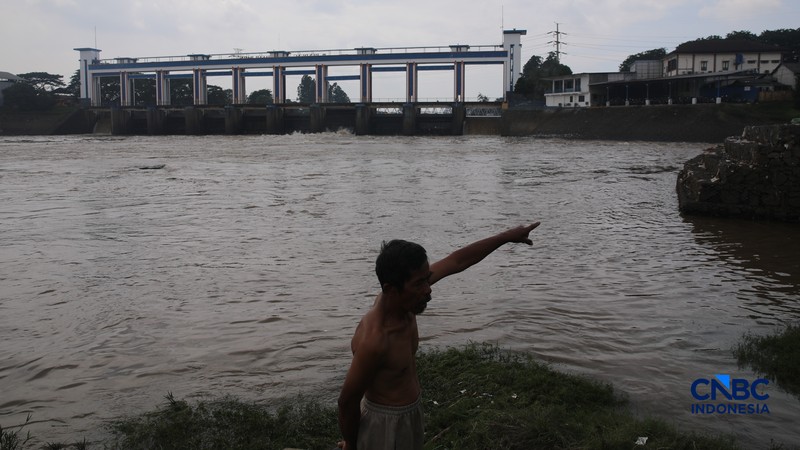 Warga mencari ikan pada aliran Sungai Cisadane yang tercemar limbah di Kota Tangerang, Banten, Kamis (12/2/2026). (CNBC Indonesia/Faisal Rahman)