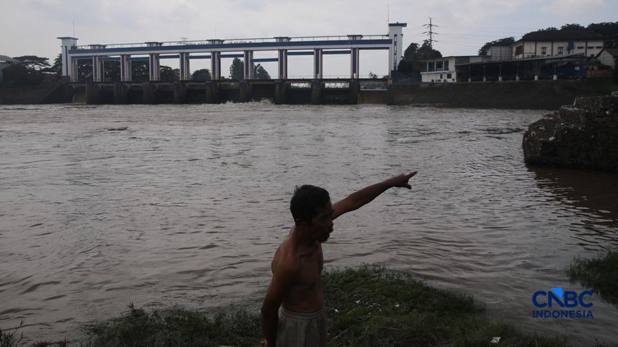 Warga mencari ikan pada aliran Sungai Cisadane yang tercemar limbah di Kota Tangerang, Banten, Kamis (12/2/2026). (CNBC Indonesia/Faisal Rahman)