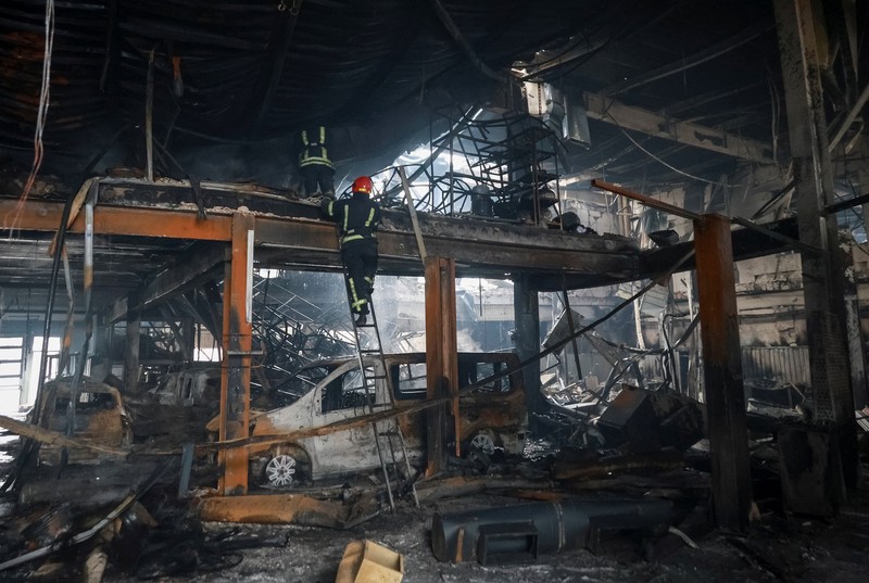 Warga berjalan di dekat mobil-mobil yang rusak di lokasi serangan pesawat tak berawak Rusia, di tengah serangan Rusia terhadap Ukraina, di Odesa, Ukraina, 13 Februari 2026. (REUTERS/Nina Liashonok)