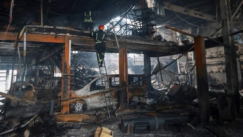 Warga berjalan di dekat mobil-mobil yang rusak di lokasi serangan pesawat tak berawak Rusia, di tengah serangan Rusia terhadap Ukraina, di Odesa, Ukraina, 13 Februari 2026. (REUTERS/Nina Liashonok)