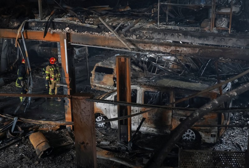 Warga berjalan di dekat mobil-mobil yang rusak di lokasi serangan pesawat tak berawak Rusia, di tengah serangan Rusia terhadap Ukraina, di Odesa, Ukraina, 13 Februari 2026. (REUTERS/Nina Liashonok)
