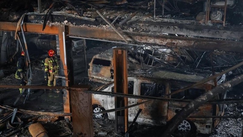 Warga berjalan di dekat mobil-mobil yang rusak di lokasi serangan pesawat tak berawak Rusia, di tengah serangan Rusia terhadap Ukraina, di Odesa, Ukraina, 13 Februari 2026. (REUTERS/Nina Liashonok)
