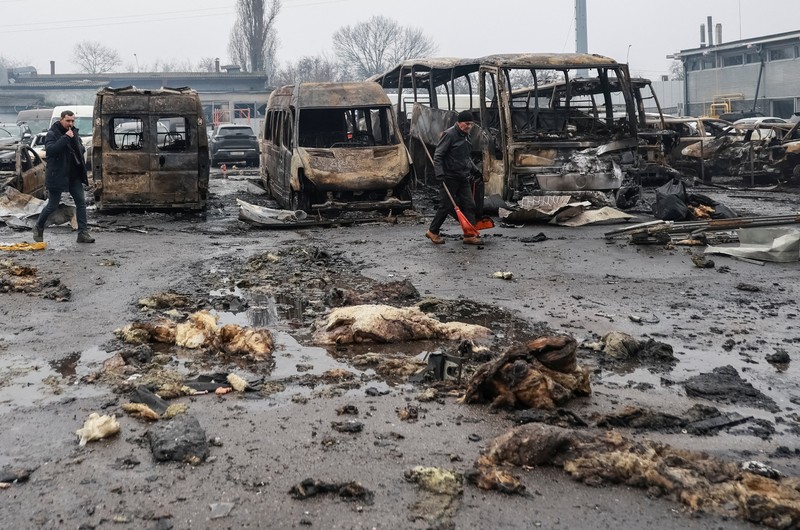 Warga berjalan di dekat mobil-mobil yang rusak di lokasi serangan pesawat tak berawak Rusia, di tengah serangan Rusia terhadap Ukraina, di Odesa, Ukraina, 13 Februari 2026. (REUTERS/Nina Liashonok)