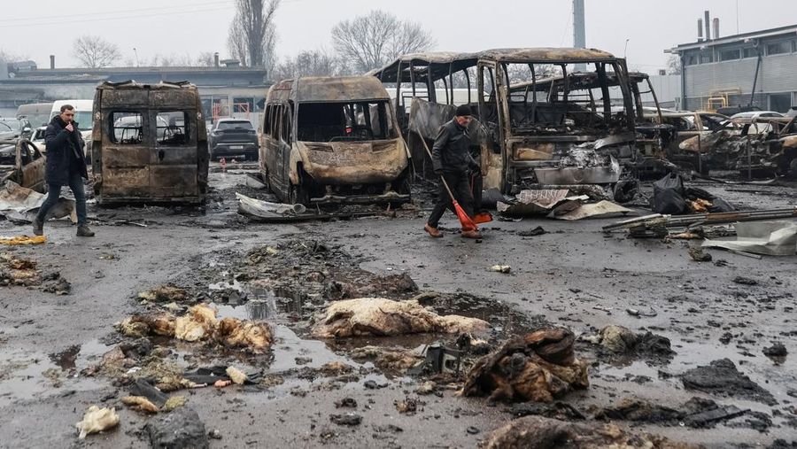 Warga berjalan di dekat mobil-mobil yang rusak di lokasi serangan pesawat tak berawak Rusia, di tengah serangan Rusia terhadap Ukraina, di Odesa, Ukraina, 13 Februari 2026. (REUTERS/Nina Liashonok)