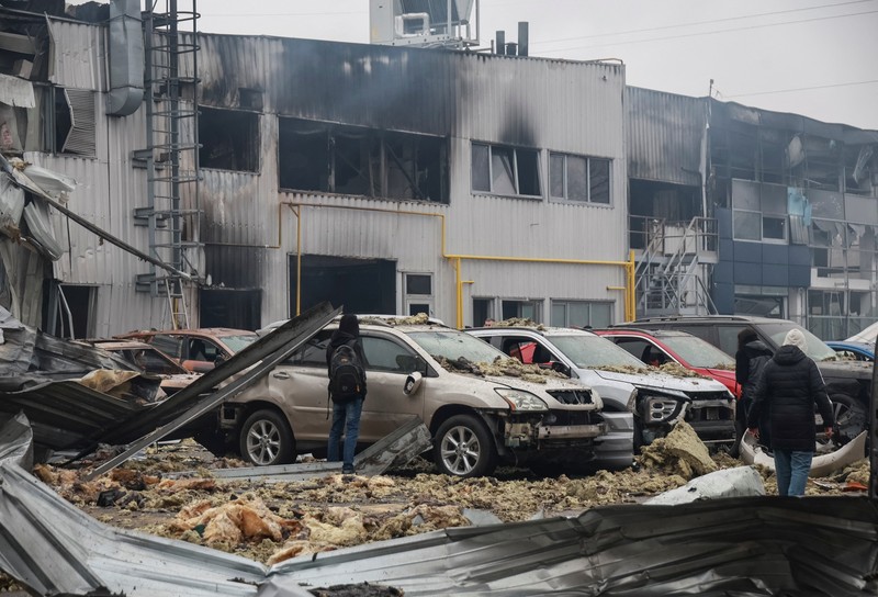 Warga berjalan di dekat mobil-mobil yang rusak di lokasi serangan pesawat tak berawak Rusia, di tengah serangan Rusia terhadap Ukraina, di Odesa, Ukraina, 13 Februari 2026. (REUTERS/Nina Liashonok)
