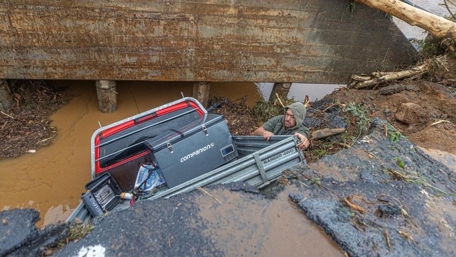 A man retrieves his gear from a utility vehicle that plunged off a collapsed section of road following heavy rain and wild winds in Puketotara, Waikato region, New Zealand, February 14, 2026 in this picture obtained from social media. Wayne Feisst/via REUTERS  THIS IMAGE HAS BEEN SUPPLIED BY A THIRD PARTY. MANDATORY CREDIT. NO RESALES. NO ARCHIVES.     TPX IMAGES OF THE DAY     VERIFICATION: Reuters was able to confirm the location of footage from terrain, road layout, vegetation and bridge seen from file and satellite images. Date of footage was confirmed from file data.