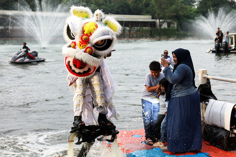 A person uses a flyboard as they perform a lion dance at Senayan Park shopping mall, ahead of the Chinese Lunar New Year, which will welcome the Year of the Horse, in Jakarta, Indonesia, February 14, 2026. REUTERS/Ajeng Dinar Ulfiana     TPX IMAGES OF THE DAY