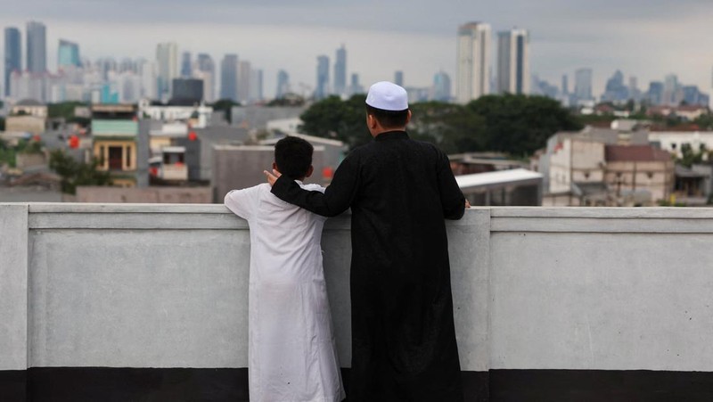 Para pria Muslim berkumpul untuk mengamati posisi bulan, guna menentukan awal bulan suci puasa Ramadan, di atap masjid Al-Musyari'in di Jakarta, Indonesia, 17 Februari 2026. (REUTERS/Ajeng Dinar Ulfiana)