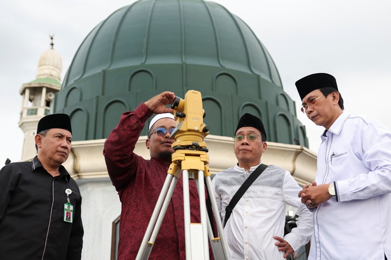 Para pria Muslim berkumpul untuk mengamati posisi bulan, guna menentukan awal bulan suci puasa Ramadan, di atap masjid Al-Musyari'in di Jakarta, Indonesia, 17 Februari 2026. (REUTERS/Ajeng Dinar Ulfiana)