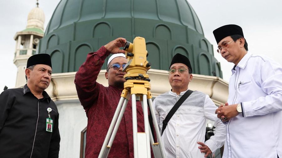 Para pria Muslim berkumpul untuk mengamati posisi bulan, guna menentukan awal bulan suci puasa Ramadan, di atap masjid Al-Musyari'in di Jakarta, Indonesia, 17 Februari 2026. (REUTERS/Ajeng Dinar Ulfiana)