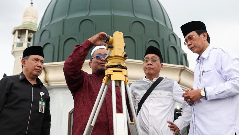 Para pria Muslim berkumpul untuk mengamati posisi bulan, guna menentukan awal bulan suci puasa Ramadan, di atap masjid Al-Musyari'in di Jakarta, Indonesia, 17 Februari 2026. (REUTERS/Ajeng Dinar Ulfiana)