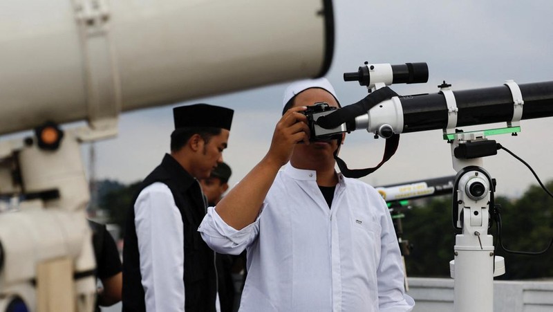 Para pria Muslim berkumpul untuk mengamati posisi bulan, guna menentukan awal bulan suci puasa Ramadan, di atap masjid Al-Musyari'in di Jakarta, Indonesia, 17 Februari 2026. (REUTERS/Ajeng Dinar Ulfiana)