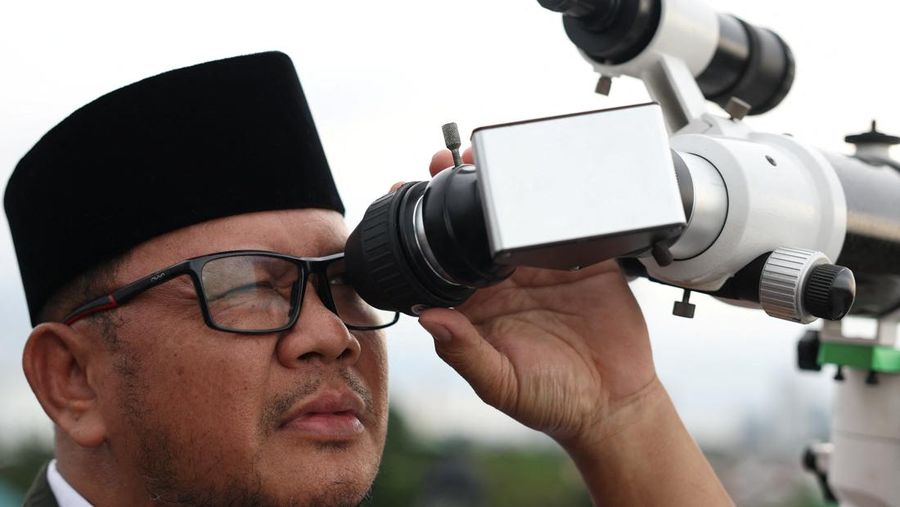 Para pria Muslim berkumpul untuk mengamati posisi bulan, guna menentukan awal bulan suci puasa Ramadan, di atap masjid Al-Musyari'in di Jakarta, Indonesia, 17 Februari 2026. (REUTERS/Ajeng Dinar Ulfiana)