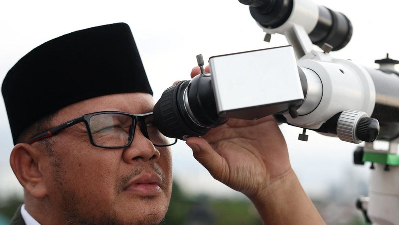 Para pria Muslim berkumpul untuk mengamati posisi bulan, guna menentukan awal bulan suci puasa Ramadan, di atap masjid Al-Musyari'in di Jakarta, Indonesia, 17 Februari 2026. (REUTERS/Ajeng Dinar Ulfiana)