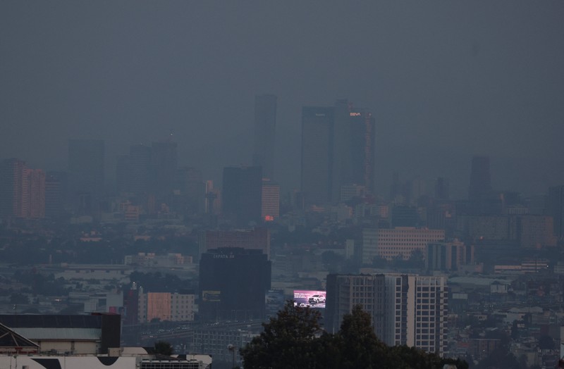 Bangunan dan rumah-rumah diselimuti kabut asap, saat pihak berwenang memerintahkan pembatasan lalu lintas karena polusi udara di Kota Meksiko, Meksiko, 17 Februari 2026. (REUTERS/Henry Romero)