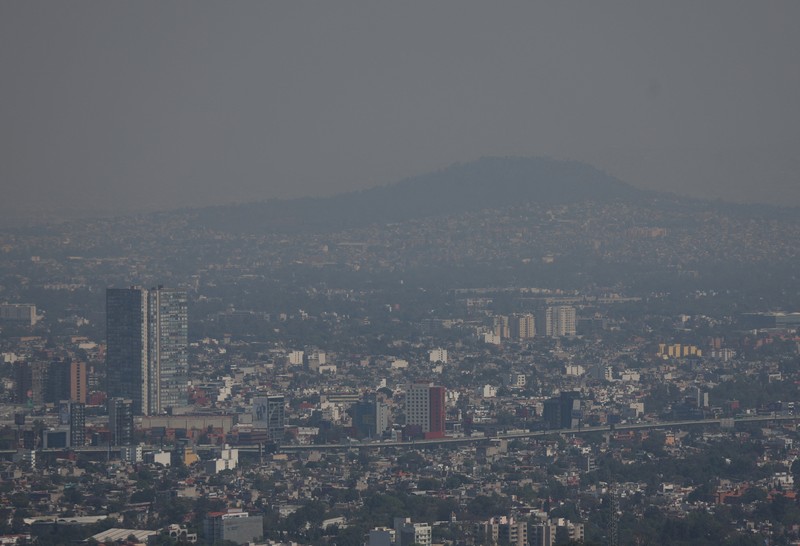 Bangunan dan rumah-rumah diselimuti kabut asap, saat pihak berwenang memerintahkan pembatasan lalu lintas karena polusi udara di Kota Meksiko, Meksiko, 17 Februari 2026. (REUTERS/Henry Romero)