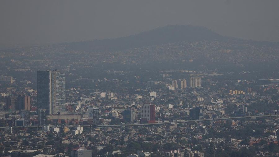 Bangunan dan rumah-rumah diselimuti kabut asap, saat pihak berwenang memerintahkan pembatasan lalu lintas karena polusi udara di Kota Meksiko, Meksiko, 17 Februari 2026. (REUTERS/Henry Romero)