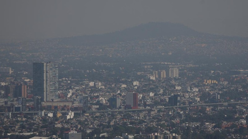 Bangunan dan rumah-rumah diselimuti kabut asap, saat pihak berwenang memerintahkan pembatasan lalu lintas karena polusi udara di Kota Meksiko, Meksiko, 17 Februari 2026. (REUTERS/Henry Romero)