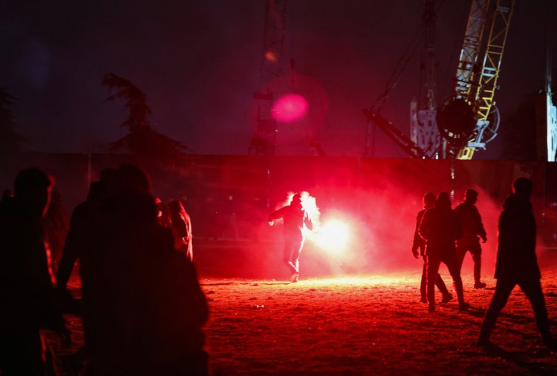 Para pengunjuk rasa melemparkan suar ke arah polisi selama demonstrasi menentang pembangunan proyek akuarium yang menurut mereka akan merusak taman umum, di Belgrade, Serbia, 17 Februari 2026. (REUTERS/Zorana Jevtic)