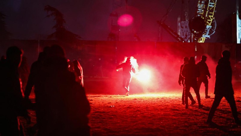 Para pengunjuk rasa melemparkan suar ke arah polisi selama demonstrasi menentang pembangunan proyek akuarium yang menurut mereka akan merusak taman umum, di Belgrade, Serbia, 17 Februari 2026. (REUTERS/Zorana Jevtic)