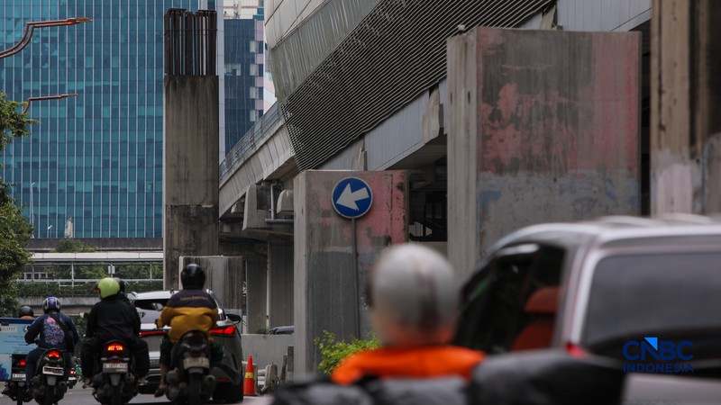 Pengendara melintas di samping tiang monorel yang telah dibongkar di Jalan HR Rasuna Said, Jakarta, Rabu (18/2/2026). (CNBC Indonesia/Faisal Rahman)