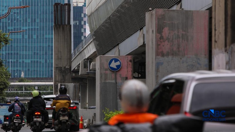 Pengendara melintas di samping tiang monorel yang telah dibongkar di Jalan HR Rasuna Said, Jakarta, Rabu (18/2/2026). (CNBC Indonesia/Faisal Rahman)