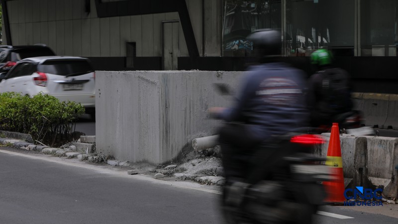 Pengendara melintas di samping tiang monorel yang telah dibongkar di Jalan HR Rasuna Said, Jakarta, Rabu (18/2/2026). (CNBC Indonesia/Faisal Rahman)