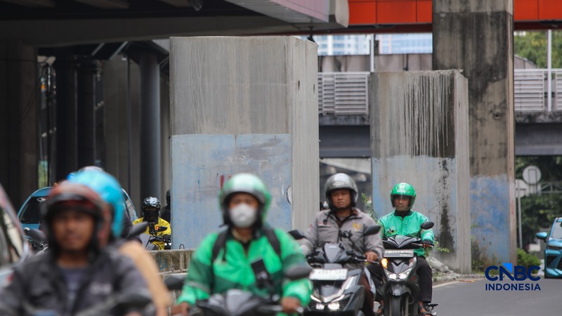 Pengendara melintas di samping tiang monorel yang telah dibongkar di Jalan HR Rasuna Said, Jakarta, Rabu (18/2/2026). (CNBC Indonesia/Faisal Rahman)