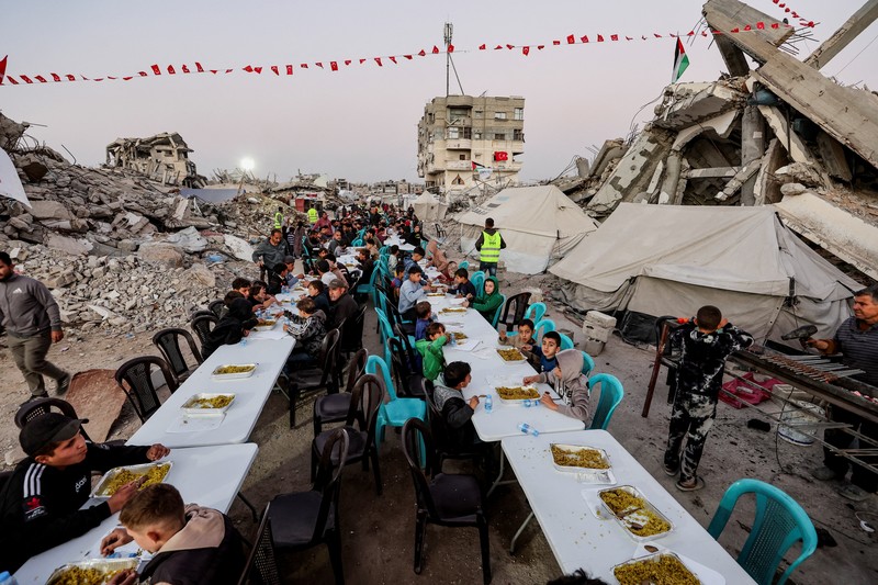 Di Gaza City, warga Palestina berkumpul untuk melaksanakan ibadah berbuka puasa pada hari pertama Ramadan. (REUTERS/Dawoud Abu Alkas)