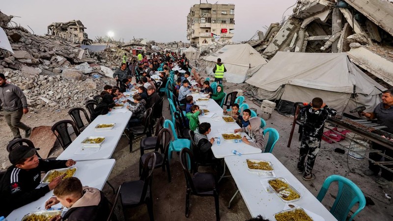 Di Gaza City, warga Palestina berkumpul untuk melaksanakan ibadah berbuka puasa pada hari pertama Ramadan. (REUTERS/Dawoud Abu Alkas)