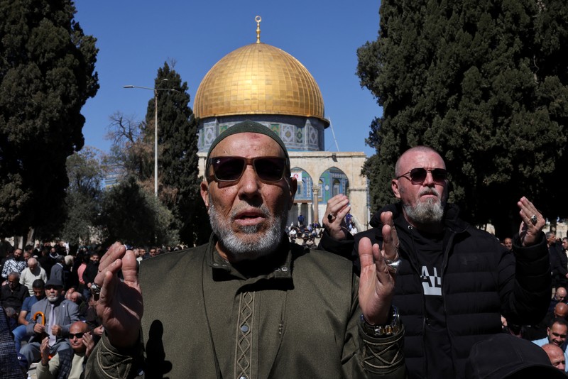Warga Palestina berbondong-bondong menuju kompleks Al-Aqsa, yang juga dikenal oleh orang Yahudi sebagai Bukit Bait Suci, di Kota Tua Yerusalem, untuk mengikuti salat Jumat pertama selama bulan suci Ramadhan, di dekat pos pemeriksaan Qalandia di Tepi Barat yang diduduki Israel, 20 Februari 2026. (REUTERS/Mohammed Torokman)