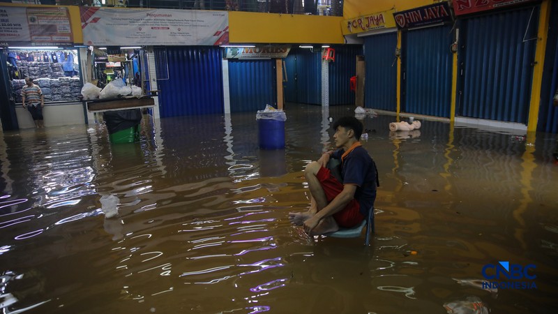 Pedagang menunggu pembeli saat banjir melanda Pasar Cipulir di Jakarta, Jumat (20/2/2026). (CNBC Indonesia/Faisal Rahman)