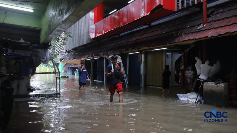 Pedagang menunggu pembeli saat banjir melanda Pasar Cipulir di Jakarta, Jumat (20/2/2026). (CNBC Indonesia/Faisal Rahman)