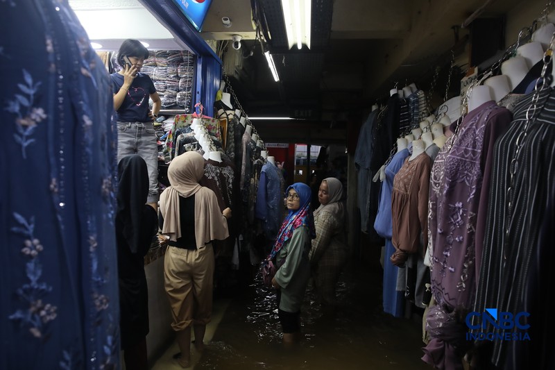 Pedagang menunggu pembeli saat banjir melanda Pasar Cipulir di Jakarta, Jumat (20/2/2026). (CNBC Indonesia/Faisal Rahman)