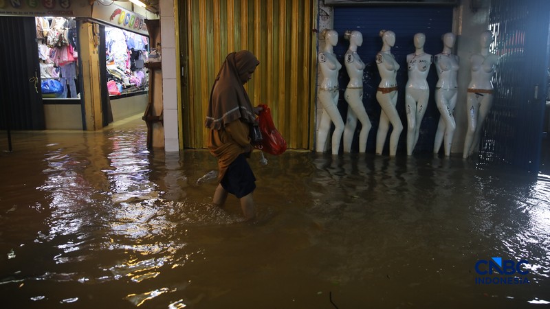 Pedagang menunggu pembeli saat banjir melanda Pasar Cipulir di Jakarta, Jumat (20/2/2026). (CNBC Indonesia/Faisal Rahman)