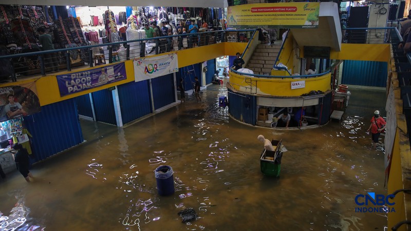 Pedagang menunggu pembeli saat banjir melanda Pasar Cipulir di Jakarta, Jumat (20/2/2026). (CNBC Indonesia/Faisal Rahman)