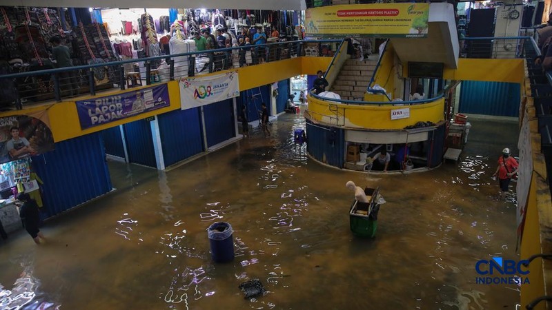 Pedagang menunggu pembeli saat banjir melanda Pasar Cipulir di Jakarta, Jumat (20/2/2026). (CNBC Indonesia/Faisal Rahman)