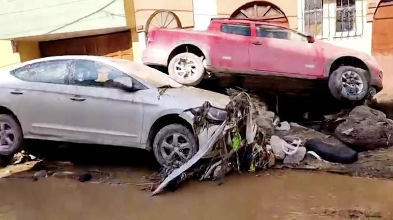 Warga membersihkan jalan setelah hujan lebat menyebabkan lingkungan tersebut tergenang lumpur dan puing-puing, di Arequipa, Peru, 19 Februari 2026. (REUTERS/Oswald Charca)