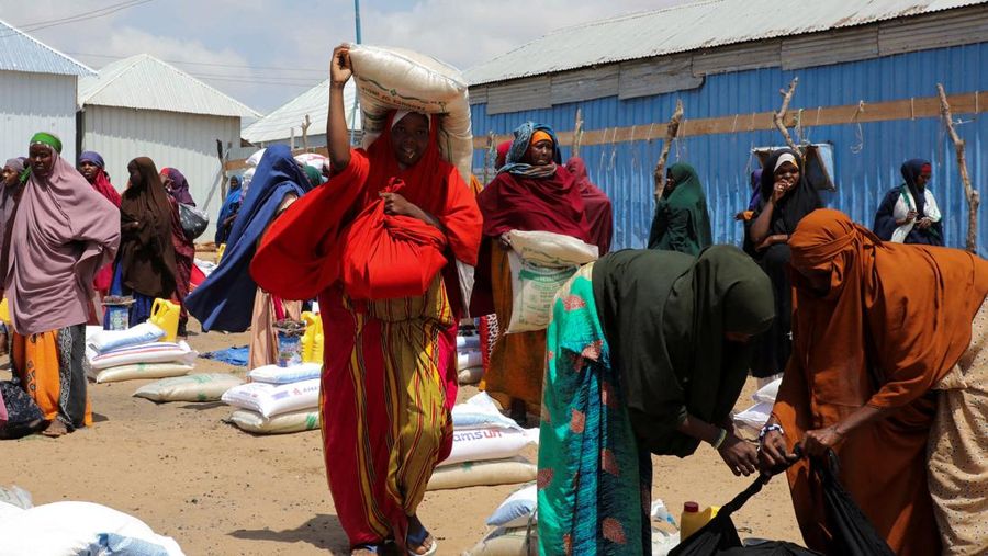IPara perempuan Somalia yang mengungsi di dalam negeri membawa paket bantuan mereka setelah menerima bantuan makanan kering dari badan amal Kuwait, selama bulan suci Ramadhan, di Mogadishu, Somalia, 12 Maret 2025. (REUTERS/Feisal Omar/File Foto)