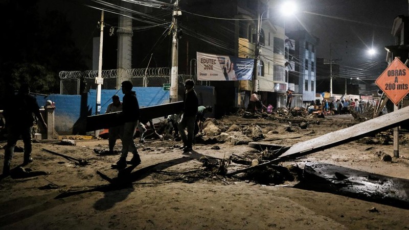 Warga membersihkan jalan setelah hujan lebat menyebabkan lingkungan tersebut tergenang lumpur dan puing-puing, di Arequipa, Peru, 19 Februari 2026. (REUTERS/Oswald Charca)