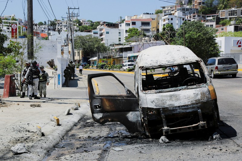 Puing-puing sebuah trailer akibat penghalang jalan dan serangan pembakaran yang dilakukan oleh anggota kejahatan terorganisir di beberapa negara bagian setelah operasi militer di mana sumber pemerintah mengatakan gembong narkoba Meksiko Nemesio Oseguera, yang dikenal sebagai
