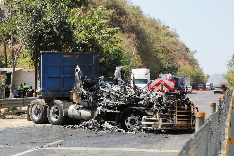 Puing-puing sebuah trailer akibat penghalang jalan dan serangan pembakaran yang dilakukan oleh anggota kejahatan terorganisir di beberapa negara bagian setelah operasi militer di mana sumber pemerintah mengatakan gembong narkoba Meksiko Nemesio Oseguera, yang dikenal sebagai
