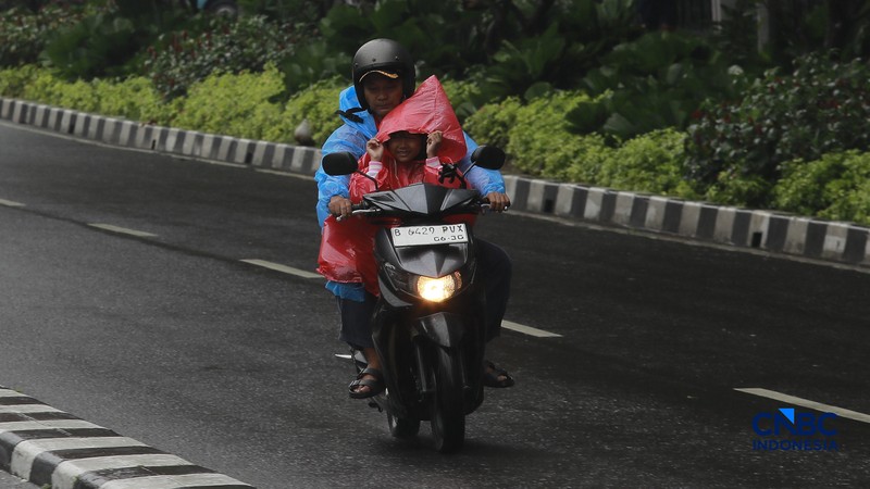 Sejumlah orang tetap melakukan aktifitas diluar rumah saat Peringatan dini cuaca Jabodetabek, Senin, (23/2/2026). (CNBC Indonesia/Muhammad Sabki)