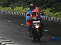 Sejumlah orang tetap melakukan aktifitas diluar rumah saat Peringatan dini cuaca Jabodetabek, Senin, (23/2/2026). (CNBC Indonesia/Muhammad Sabki)