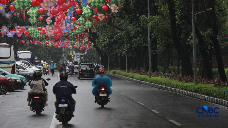 Sejumlah orang tetap melakukan aktifitas diluar rumah saat Peringatan dini cuaca Jabodetabek, Senin, (23/2/2026). (CNBC Indonesia/Muhammad Sabki)