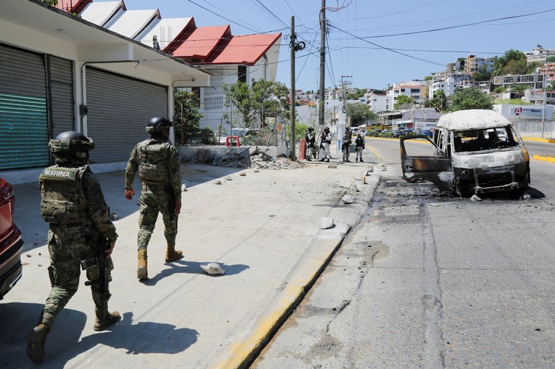 Puing-puing sebuah trailer akibat penghalang jalan dan serangan pembakaran yang dilakukan oleh anggota kejahatan terorganisir di beberapa negara bagian setelah operasi militer di mana sumber pemerintah mengatakan gembong narkoba Meksiko Nemesio Oseguera, yang dikenal sebagai