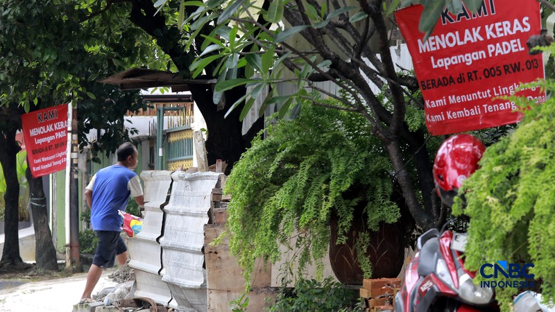 Deretan spanduk penolakan terbentang di pagar dan sudut jalan lingkungan RT 05/13, Pulomas, Jakarta Timur,  Selasa, (24/2/2026). (CNBC Indonesia/Muhammad Sabki)